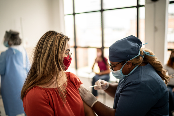  Teenager girl being vaccinated - wearing face mask