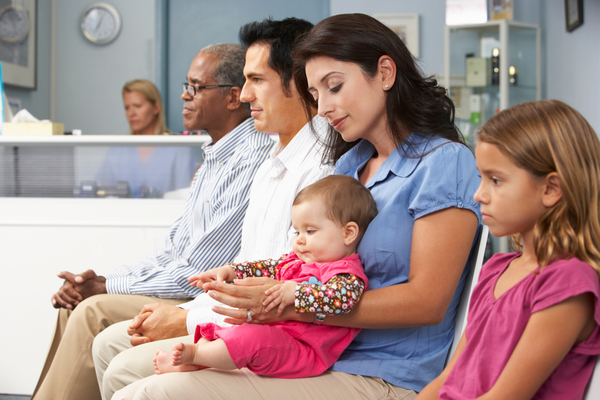 Patients In Busy Doctors Waiting Room