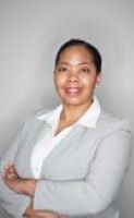 Jennifer Erves poses in a gray blazer and collared white top with her arms crossed.
