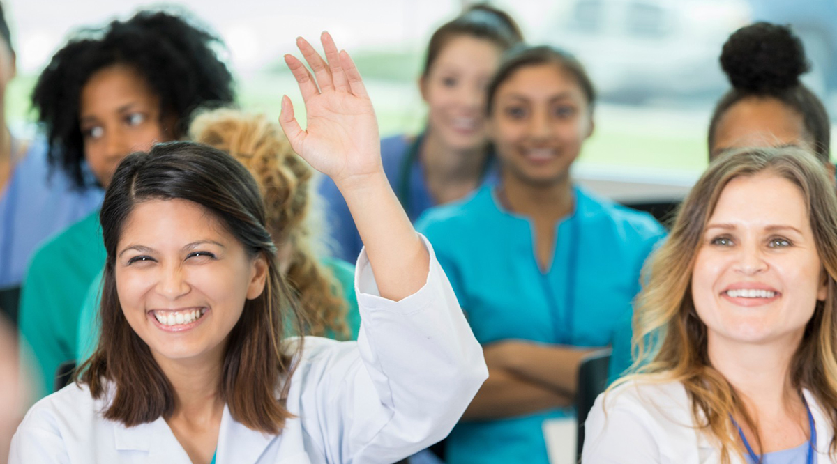 Cheerful female doctor asks question at medical seminar