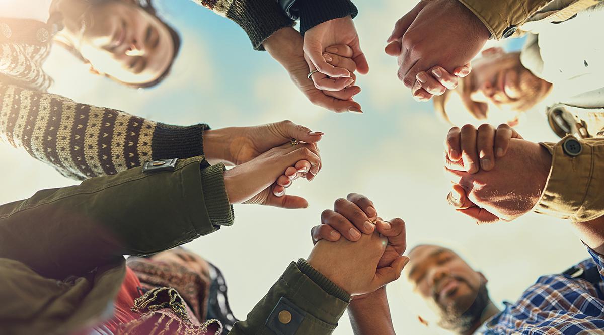 Four people holding hands in a circle